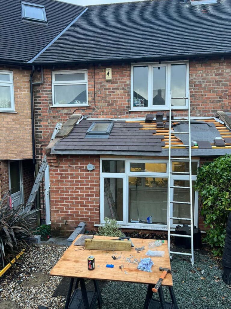 This is a photo of a roof extension that is having new roof tiles installed. This is a photo taken from the roof ridge looking down a tiled pitched roof on to a flat roof. Works carried out by Calverton Roofing Repairs